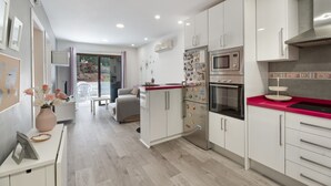 Eine moderne Küche mit weißen Schränken, einer roten Arbeitsplatte und einer eingebauten Mikrowelle.