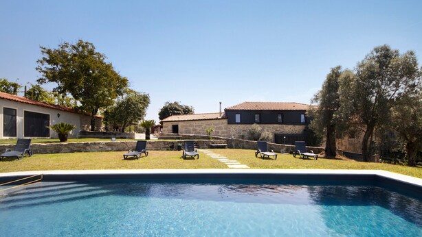 A swimming pool with lounge chairs, a stone building, and a clear sky. - Room 7 with private bathroom, Wi-Fi, and air conditioning (Rossas)