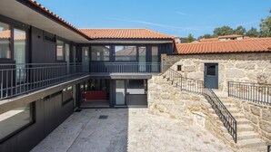 A modern building with a stone facade, a balcony, and a clear sky.
