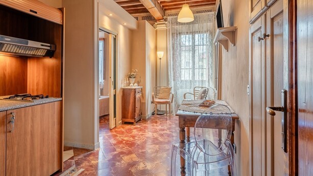Cuina amb armaris de fusta, forns integrats i zona de menjador amb taula i cadires.