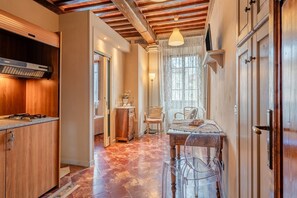 Una cocina con armarios de madera, estufa empotrada y comedor con mesa y sillas.