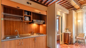 Cuina amb armaris de fusta, una aixeta d'acer inoxidable i una campana extractora integrada.