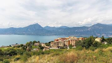 A coastal village with buildings overlooking a lake and mountains.