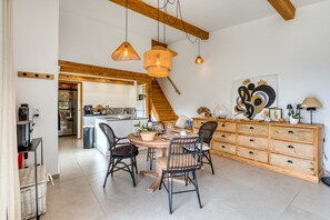 Ein Essbereich mit Holztisch, Stühlen und einer Treppe, die zur Küche führt.