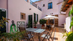 Eine Terrasse mit Tisch, Stühlen, Topfpflanzen und einem Hängesessel.