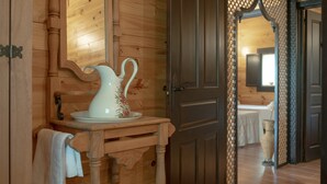 Un intérieur en bois avec une table en bois, une carafe et un miroir.