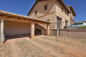 A two-story building with a covered patio and a car parked outside.