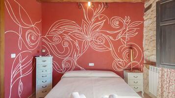 Un dormitorio con una cama, un aparador y una mesita de noche.