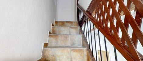 Una escalera de piedra con barandilla de madera.