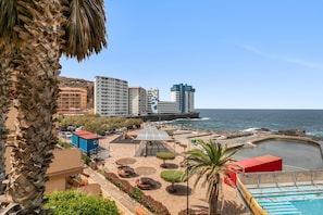 Un hôtel situé sur la côte, doté d’une piscine, d’un espace extérieur aménagé et offrant une vue sur la mer.