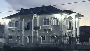 A large, multi-story building with a symmetrical facade, multiple windows, and a prominent entrance.