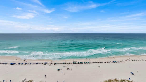 Una playa extensa con aguas azules cristalinas y una orilla arenosa.