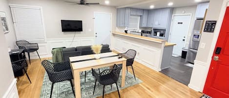 A modern kitchen with grey cabinets, a microwave, and a refrigerator.
