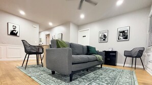 A living room with a grey sofa, patterned rug, and black chairs. - Cozy 3BR Retreat • Near ATL Airport & Downtown (Conley)