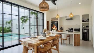 Cozinha moderna com ilha central, janelas amplas e vista para uma piscina.