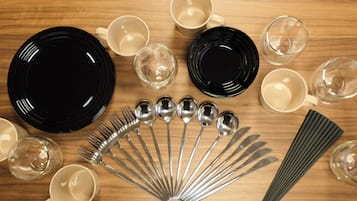 A wooden table with various dining utensils and plates.