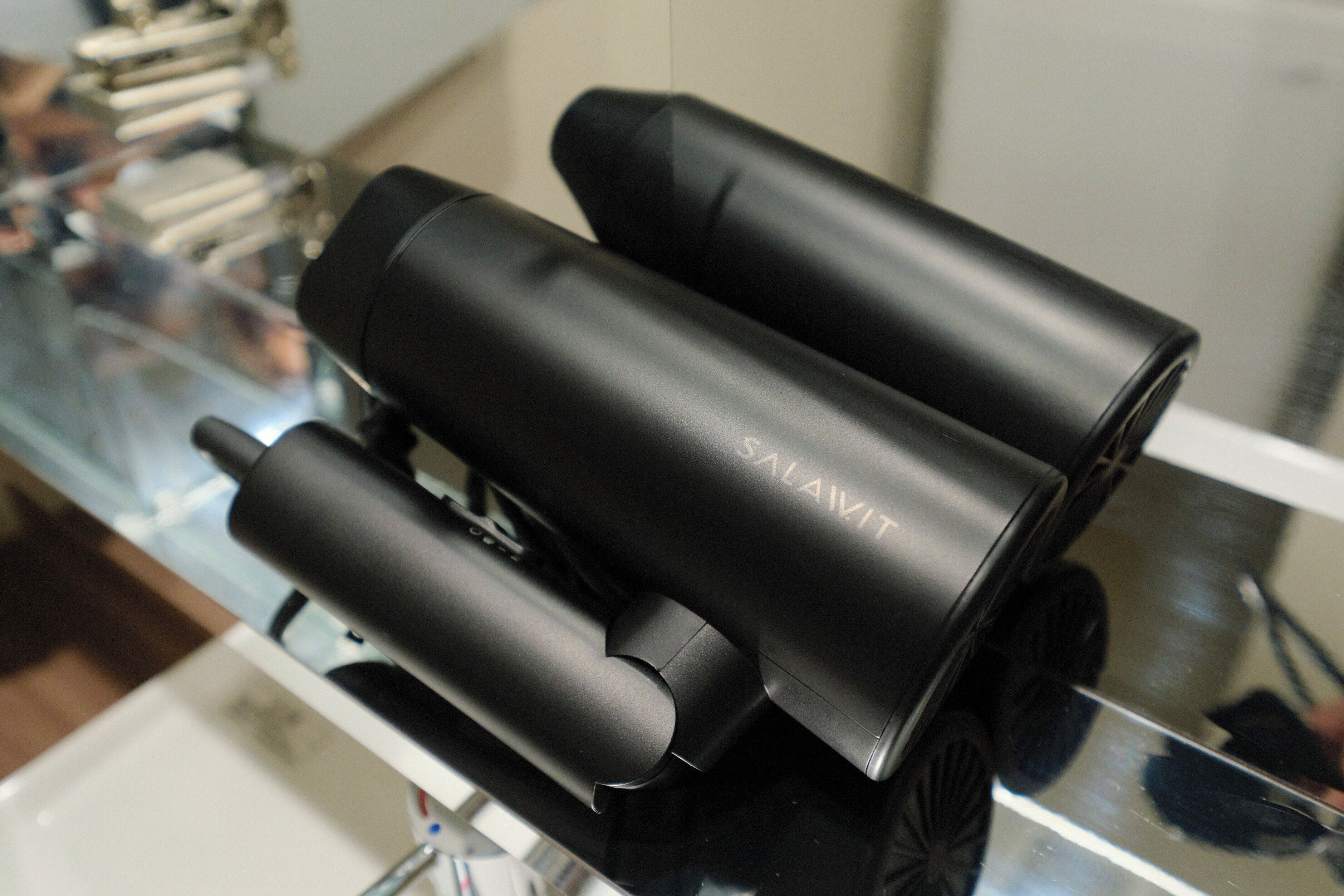 Three black cylindrical objects with the text "SALAVIT" on one.