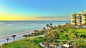A coastal hotel with a view of the sea, a grassy area with palm trees, and a paved walkway. - 2 Bedroom 2 Bathroom Condo on the Beach in Park Shore (Naples)