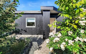 A modern house with a dark exterior, a window, and a door. - Stunning apartment in Skagen with WiFi (Skagen)