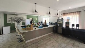 A modern kitchen with a central island, bar stools, a water refill station, and a refrigerator. - Room in Lodge - Zambezi Boutique Lodge Suite 1 With Free 4x4 Tour by Savannah Adventures (Victoria Falls)