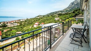 A balcony with a view of a coastal town, a mountain, and the sea. - Bellavista by Interhome (Makarska)