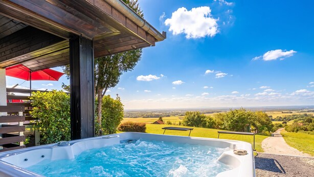 A hot tub with a wooden deck and a red umbrella, surrounded by greenery and a scenic view. - House VilAna: Jacuzzi, Garden & BBQ, Puconci, Slovenia (Puconci)