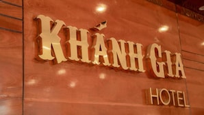 Une enseigne d’hôtel avec le nom « KHANH GIA HOTEL » écrit en grandes lettres et en caractères gras.