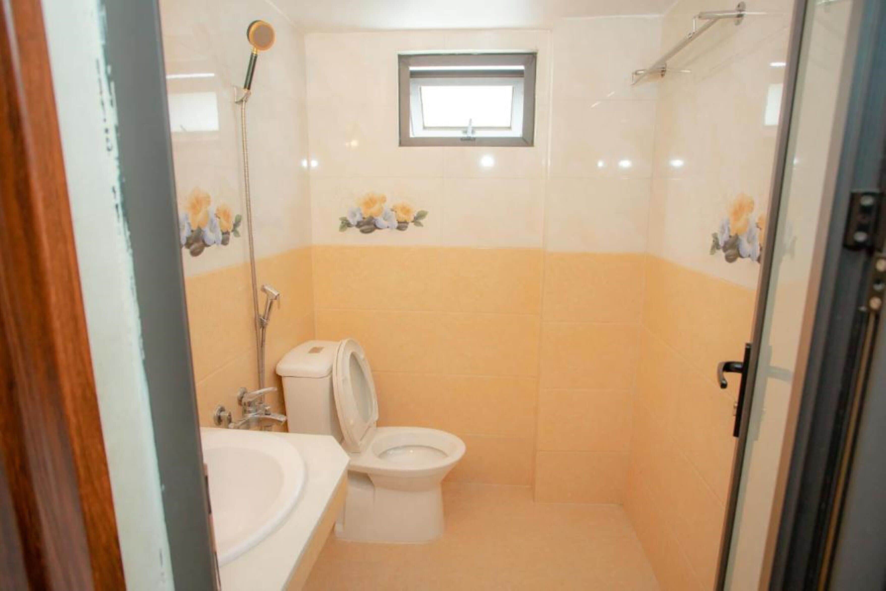 Une salle de bain avec des toilettes, un bidet et une petite fenêtre.