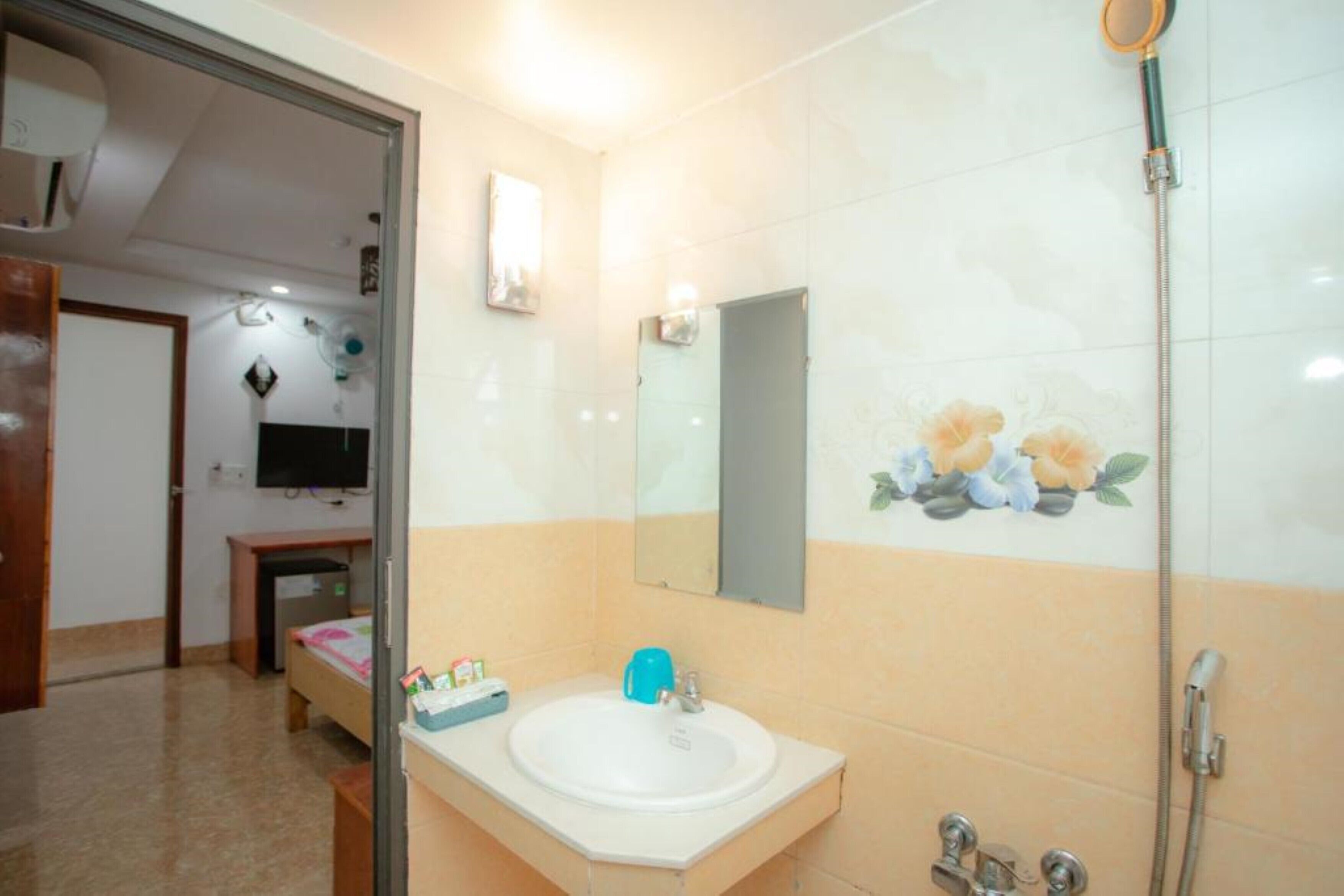 A bathroom with a sink, mirror, and shower.