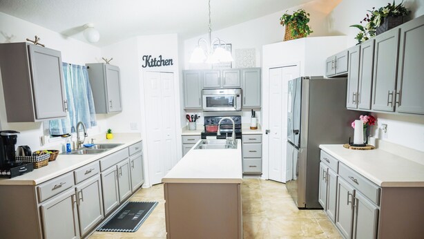 A modern kitchen with grey cabinets, a central island, a microwave, and a refrigerator. - Emely's place 

5 minutes from Jacksonville international airport (Jacksonville)
