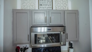 A kitchen with a stainless steel Maytag oven and microwave, grey cabinets, and a wall-mounted sign with kitchen rules. - Emely's place 

5 minutes from Jacksonville international airport (Jacksonville)