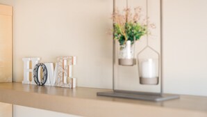 A minimalist decor with a hanging planter and the word "HOME" on a table. - GuestReady - Hideaway in Porto (Porto)