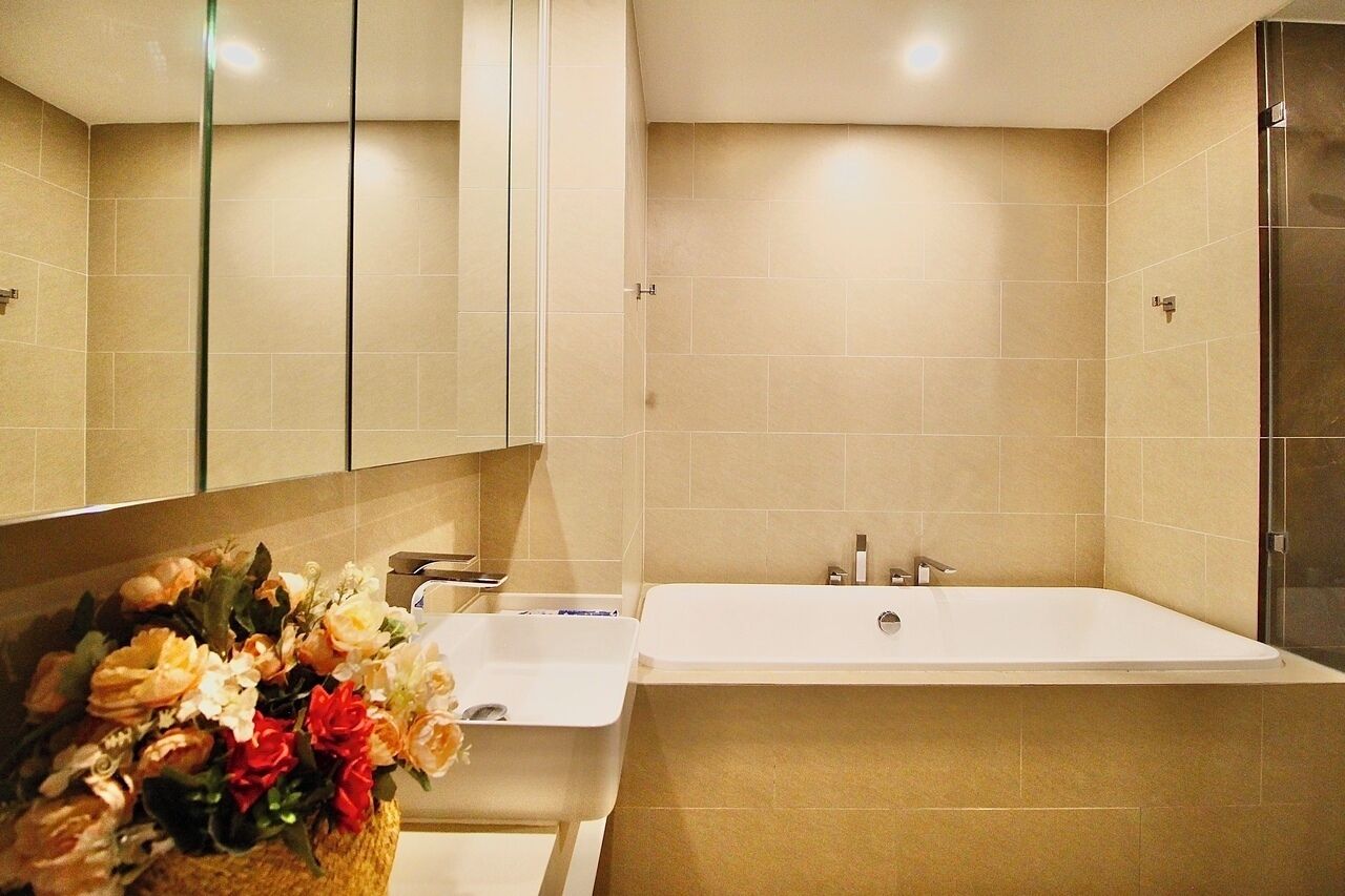 Une salle de bain moderne avec une baignoire, un lavabo et un miroir.