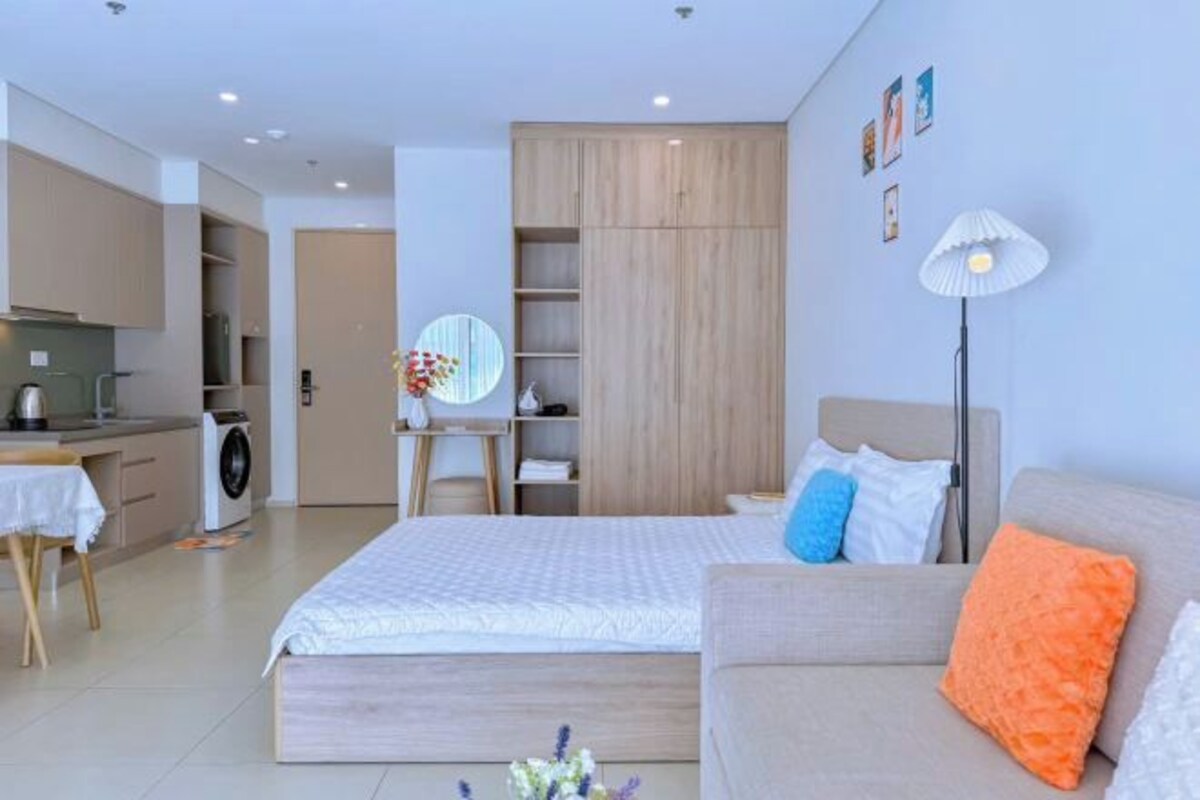 Un dormitorio moderno con cama, sofá, escritorio y armario.