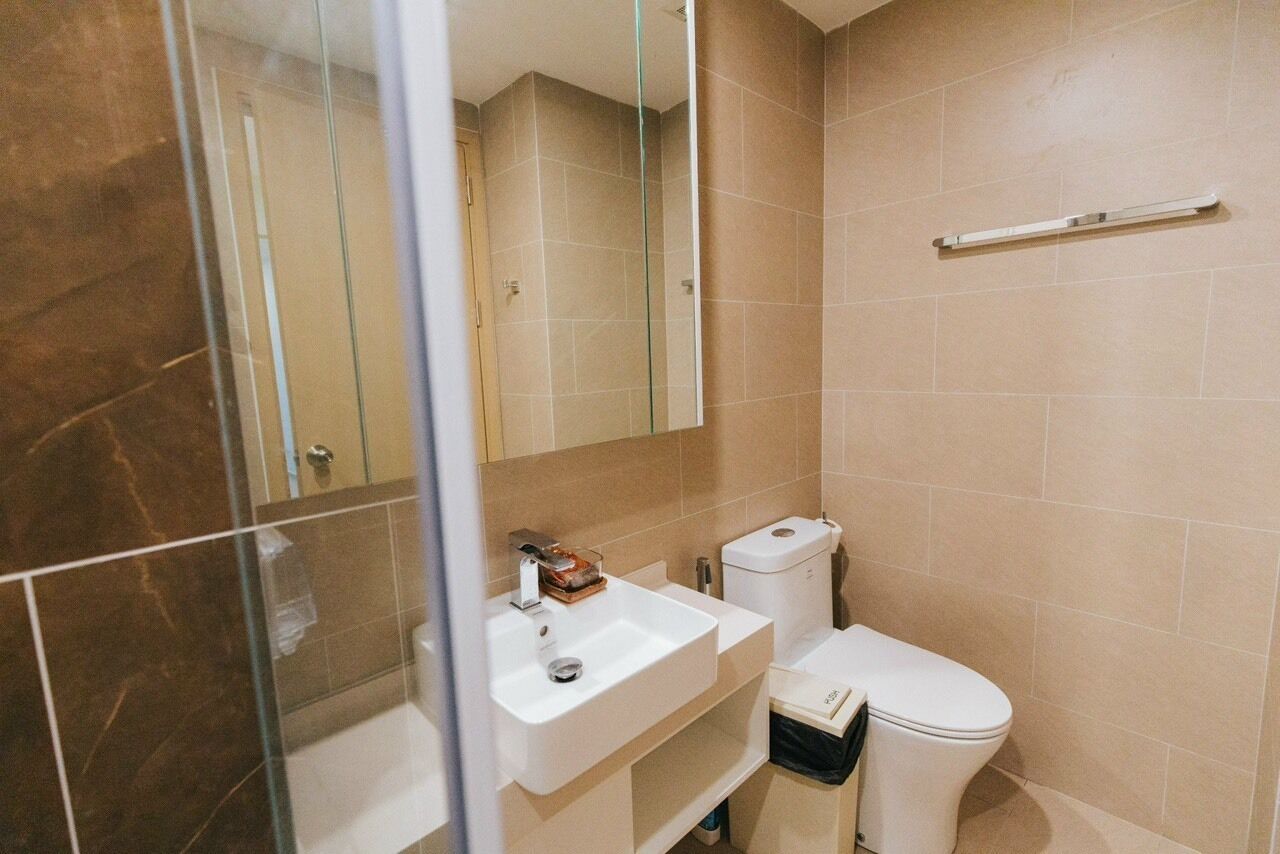 Ein Badezimmer mit Duschabtrennung aus Glas, einem weißen Waschbecken und einer Toilette.
