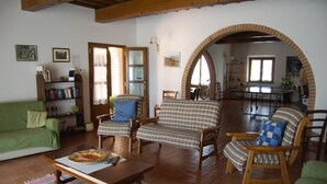 A cozy living room with a green sofa, two plaid armchairs, a wooden coffee table, and a dining area with a table and chairs. - CASALE TRIESTE - APT - CASALE TRIESTE - NUM. 12 (Laiatico)