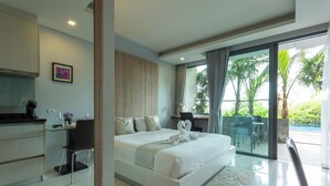 A modern bedroom with a large bed, a desk, and a view of a balcony with palm trees. - Luxury Everything Walking Distance c112 (Rawai)