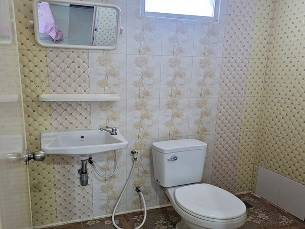 A bathroom with a toilet, sink, and a small window. - Orchid Residence At Amata (Phan Thong)