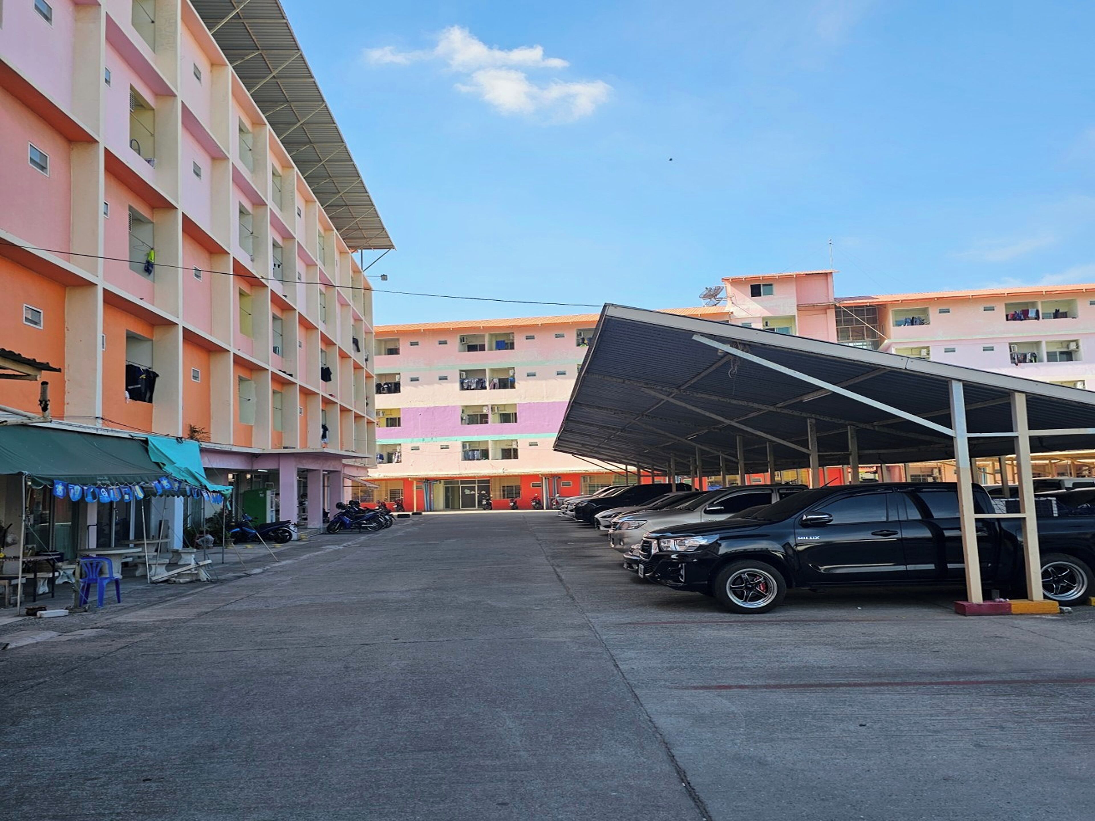A multi-story parking structure with a covered area and several parked cars.