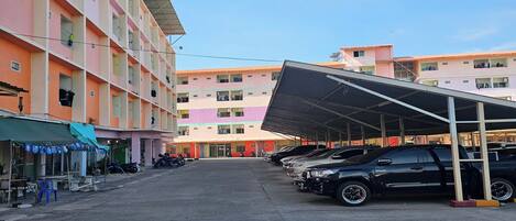 A multi-story parking structure with a covered area and several parked cars.