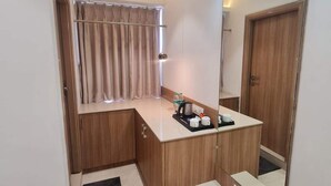 Une salle de bain moderne et compacte, dotée d’un meuble-lavabo, d’un miroir et d’un espace douche.
