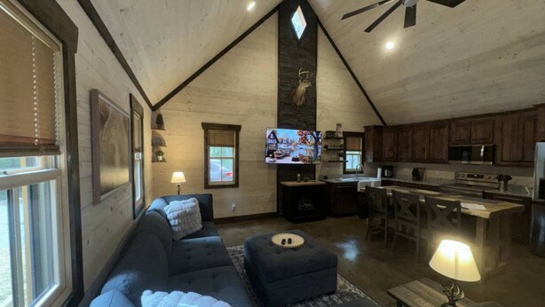 Ein gemütlicher Lofts-Wohnbereich mit einer großen Couch, einem Fernseher und einer Küchenzeile.