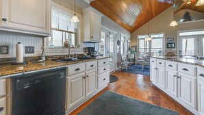 A spacious kitchen with white cabinetry, granite countertops, and a wooden ceiling. - Riverfront Aurora Home w/ Deck & Private Pier! (Aurora)