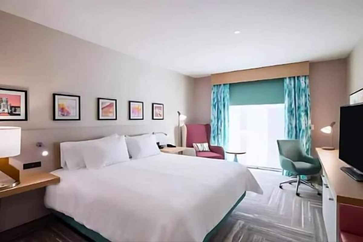 Escritorio, cortinas blackout y tabla de planchar con plancha