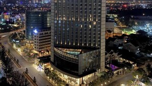 A high-rise hotel with multiple floors, a central courtyard, and a swimming pool. - Oasky Vung Tau (Ho Chi Minh City)