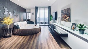 A modern bedroom with a large bed, a TV, and a view of the sea. - Oasky Vung Tau (Ho Chi Minh City)