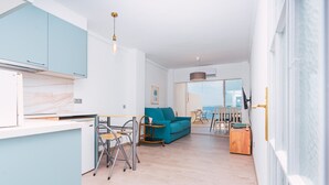 A modern living space with a kitchen, dining area, and a view of the sea. - WELCS APARTAMENTO 181 EMP con vistas al mar (Rosas / Roses)