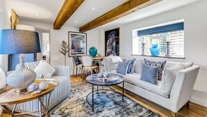 A living room with striped sofas, a coffee table, a lamp, and decorative items.
