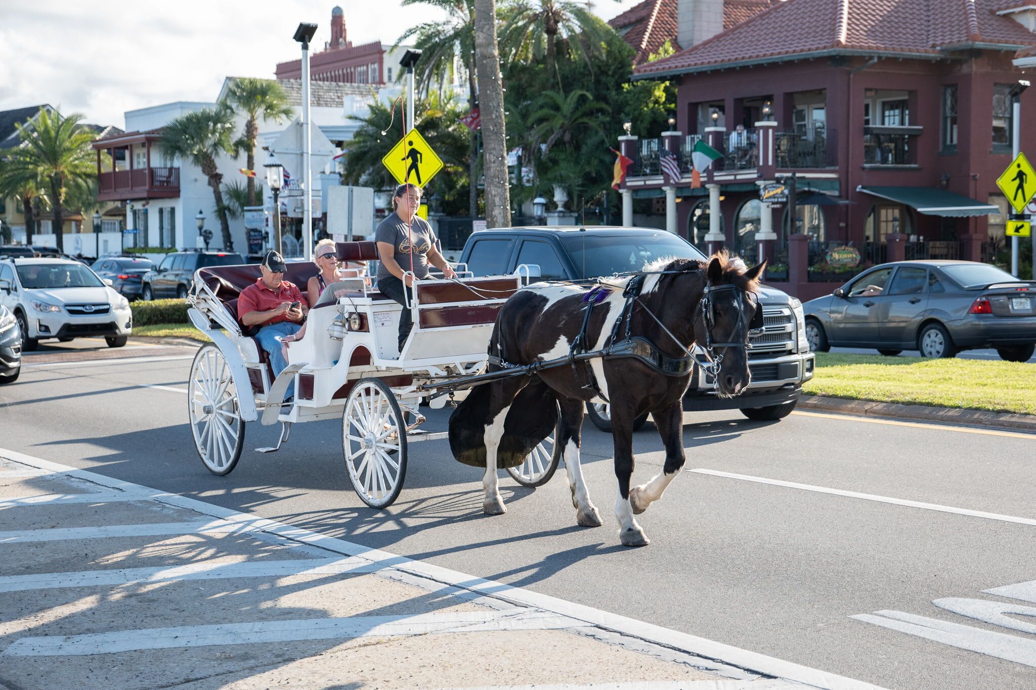 Une calèche tirée par des chevaux transportant des passagers dans une rue de la ville.