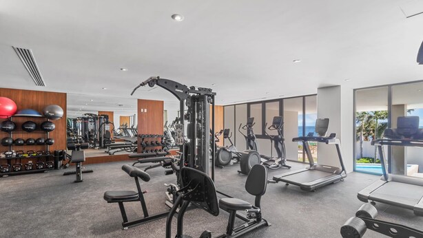 A modern gym with various exercise equipment, including treadmills and weight machines.